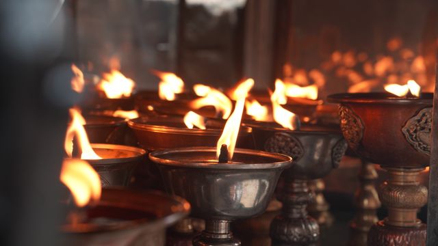 A warm close-up of butter lamps offering light, a key Buddhist tradition in Bhutan.
